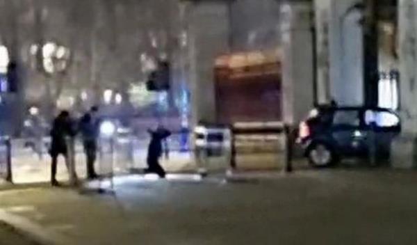 Video grab from the aftermath of the dramatic moment a car crashed into Buckingham Palace has been captured on camera. Footage of the incident shows the car, with its hazard lights on, rammed into the main entrance gates of the royal residence in Westminster, central London. Photo released March 10 2024. See SWNS story SWTPpalace.A man is on the ground on his knees behind the car, and an armed police officer can be heard yelling: Keep your hands on top of your head! The Met Police said a man had been arrested on suspicion of criminal damage.