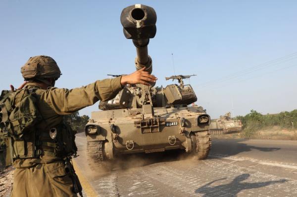 An Israeli soldier directs a self-propelled howitzer near the southern city of Ashkelon on October 8, 2023
